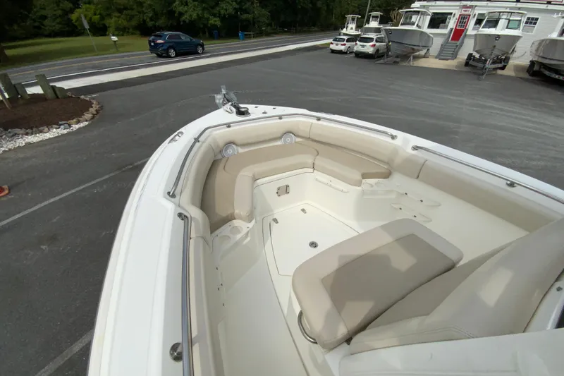Slide: The Image of 2019 Boston Whaler 230 Outrage boat interior with cushioned seating, parked outdoors. - 40