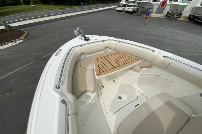 Slide: The Image of 2019 Boston Whaler 230 Outrage boat interior with seating and table, parked on pavement. - 45