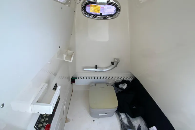 Slide: The Image of Interior of 2019 Boston Whaler 230 Outrage boat with compact toilet and storage. - 54
