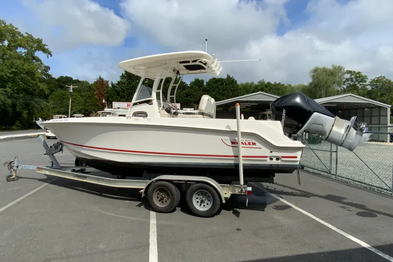 Slide: The Image of 2019 Boston Whaler 230 Outrage boat on trailer in parking lot. - 6