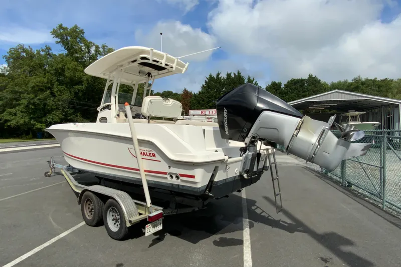Slide: The Image of 2019 Boston Whaler 230 Outrage boat on trailer, featuring a powerful Mercury outboard engine. - 7