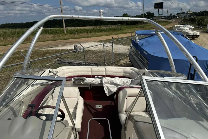 Slide: The Image of 1997 Maxum 2300 SR boat interior with white and red seating, parked outdoors. - 1