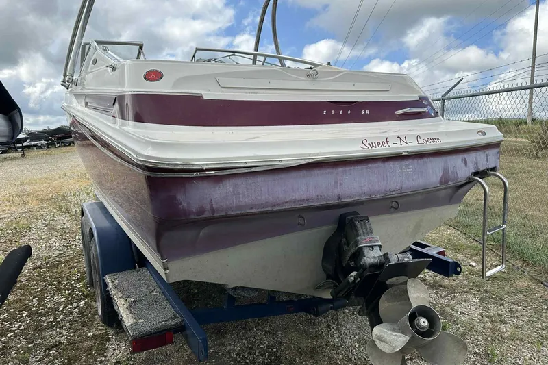 Slide: The Image of 1997 Maxum 2300 SR boat on trailer, rear view with propeller and ladder. - 12
