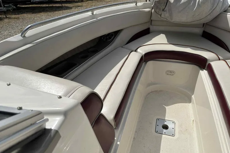 Slide: The Image of 1997 Maxum 2300 SR boat interior with cushioned seating and cup holders. - 16