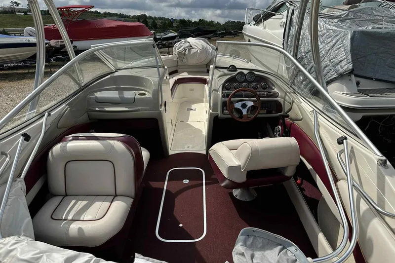 Slide: The Image of 1997 Maxum 2300 SR boat interior with white and burgundy seating, dashboard, and steering wheel. - 19
