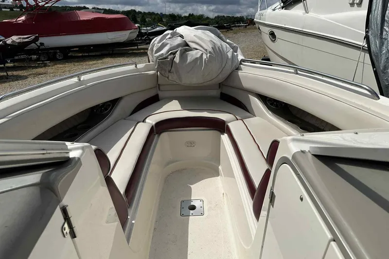 Slide: The Image of 1997 Maxum 2300 SR boat interior with white and maroon seating, docked outdoors. - 3