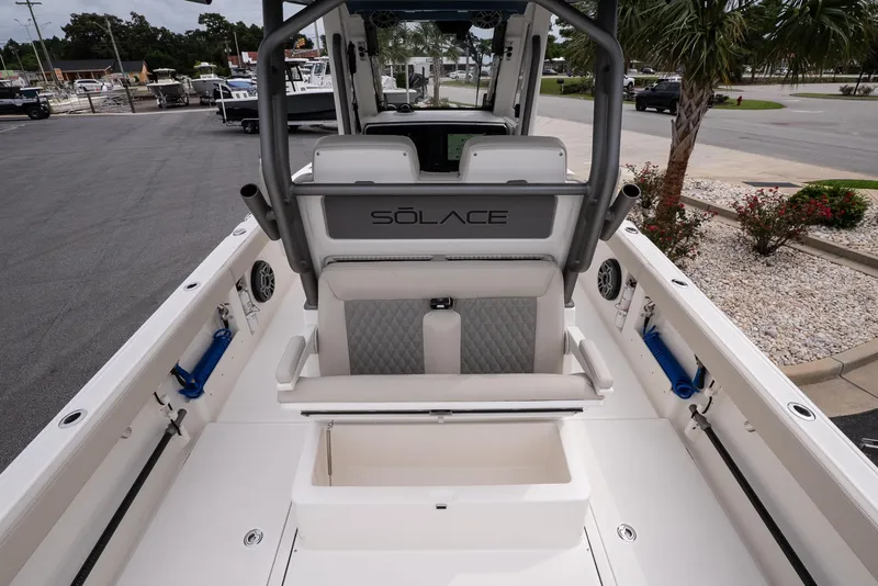 Slide: The Image of 2026 Solace 28 HCS boat interior with seating and storage, docked outdoors. - 12