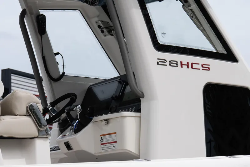 Slide: The Image of 2026 Solace 28 HCS boat interior with steering wheel and control panel. - 8