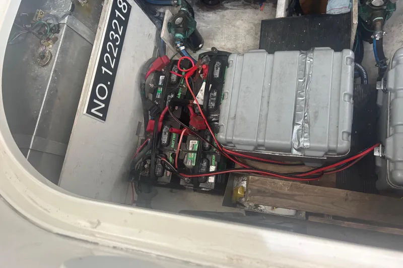 Slide: The Image of Battery compartment of a 2006 Sea Ray 320 Sundancer with wiring and storage boxes. - 12