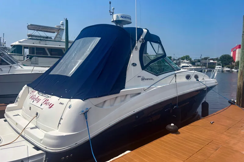 Slide: The Image of 2006 Sea Ray 320 Sundancer docked, featuring a blue canopy and sleek design. - 3