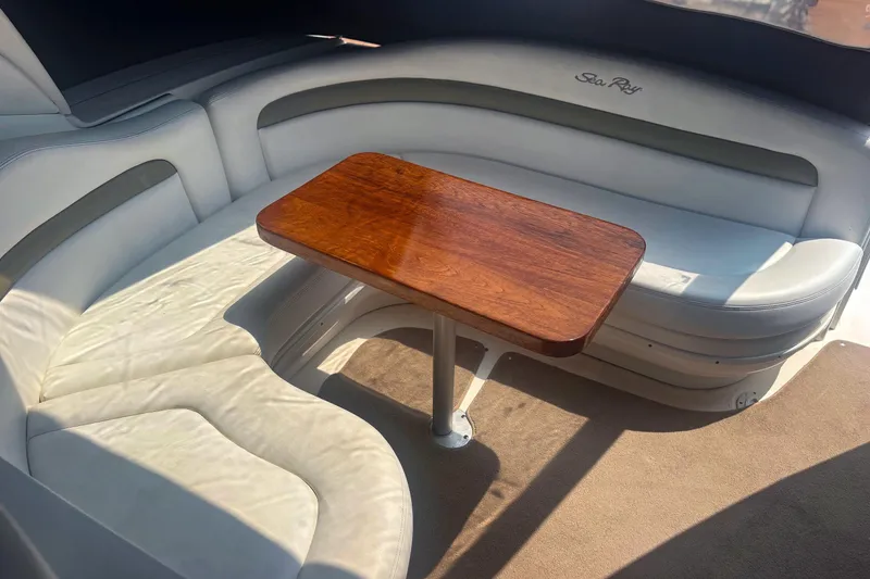 Slide: The Image of 2006 Sea Ray 320 Sundancer interior with white seating and wooden table. - 6