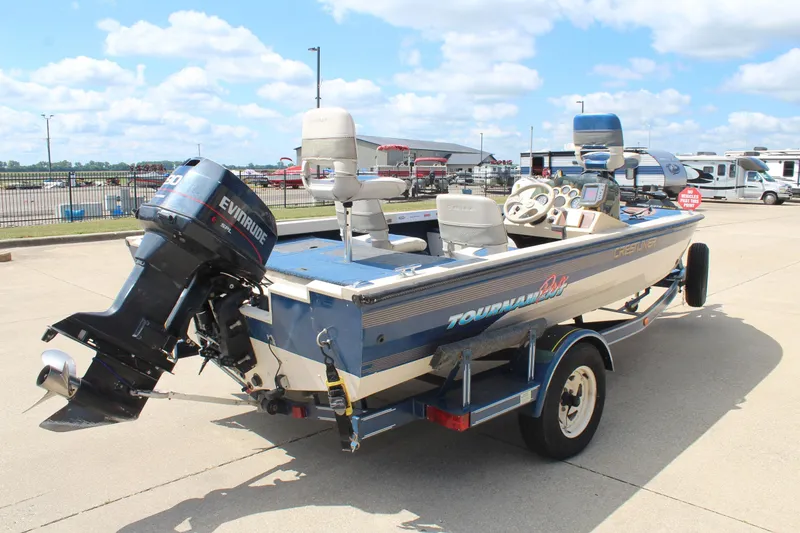 Slide: The Image of 1997 Crestliner 1750 Tournament Pro boat with Evinrude motor on trailer, parked outdoors. - 4