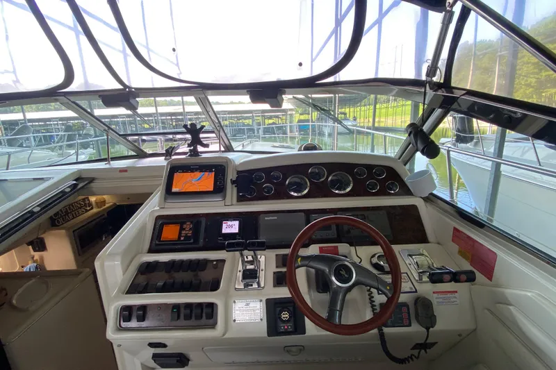 Slide: The Image of 1997 Sea Ray 400 Express Cruiser helm with navigation equipment and steering wheel. - 12