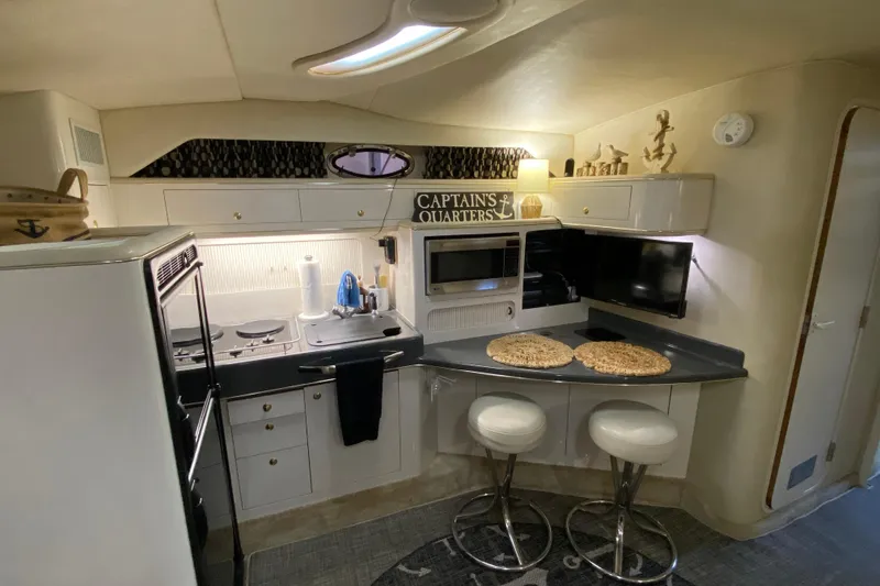 Slide: The Image of Interior of 1997 Sea Ray 400 Express Cruiser with modern kitchen and seating area. - 15