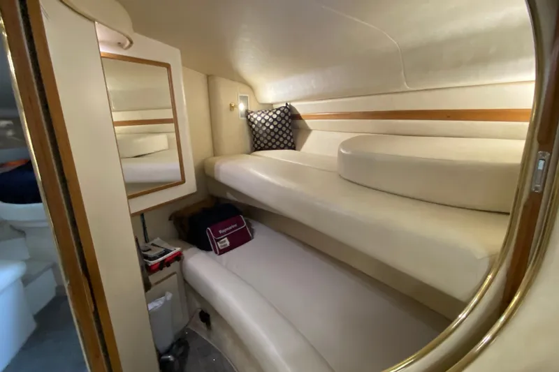 Slide: The Image of 1997 Sea Ray 400 Express Cruiser cabin with beige interior and cozy seating. - 17