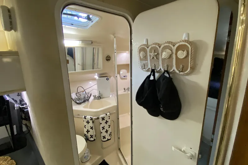Slide: The Image of 1997 Sea Ray 400 Express Cruiser bathroom with nautical decor and compact amenities. - 20