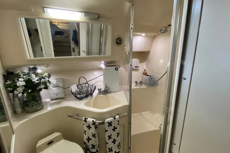 Slide: The Image of Bathroom interior of 1997 Sea Ray 400 Express Cruiser with sink, mirror, and shower. - 21
