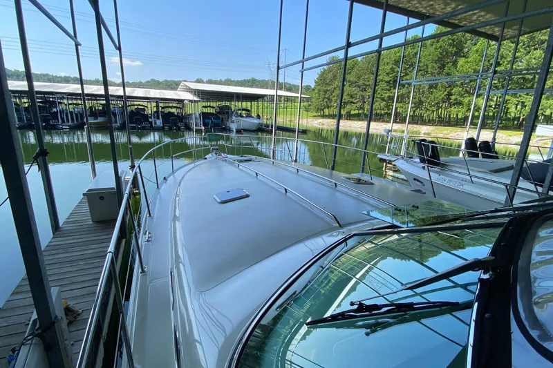 Slide: The Image of 1997 Sea Ray 400 Express Cruiser docked at marina, surrounded by trees and calm water. - 28
