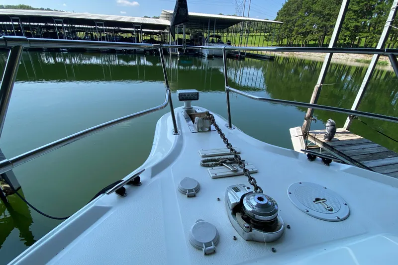 Slide: The Image of 1997 Sea Ray 400 Express Cruiser bow view at marina dock, calm water reflection. - 29