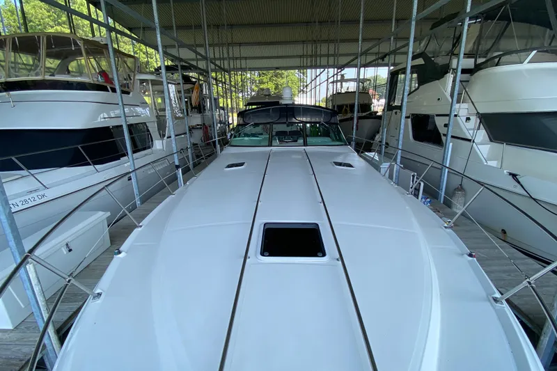 Slide: The Image of 1997 Sea Ray 400 Express Cruiser docked in a marina, surrounded by other boats. - 30