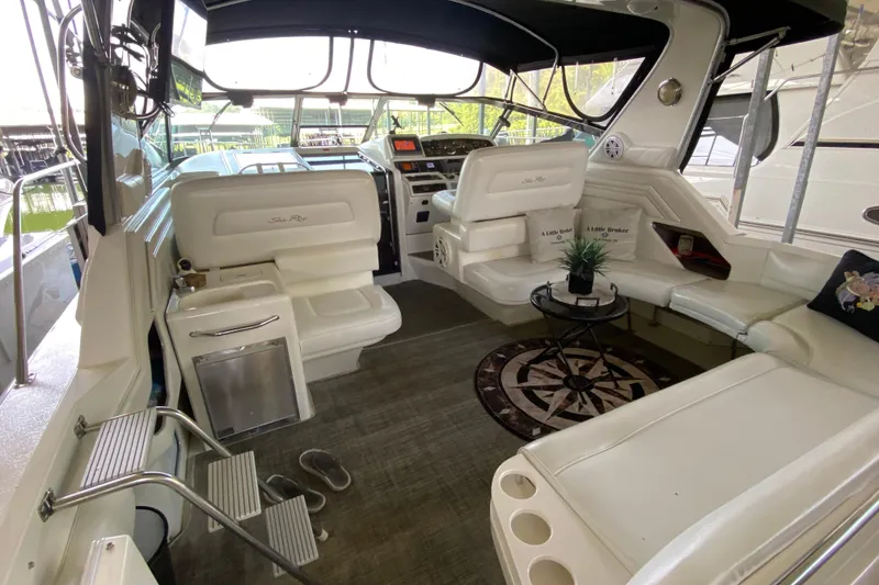 Slide: The Image of 1997 Sea Ray 400 Express Cruiser interior with white seating and helm, featuring modern amenities. - 6