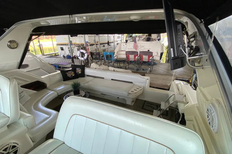 Slide: The Image of 1997 Sea Ray 400 Express Cruiser interior with white seating and outdoor view. - 8