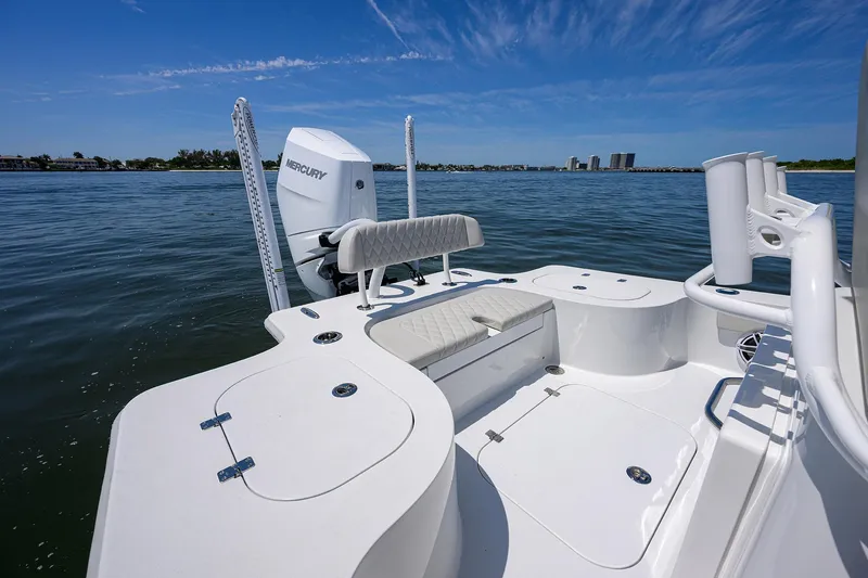 Slide: The Image of 2024 Conch 25 boat with Mercury engine on calm water, featuring spacious deck and seating. - 22