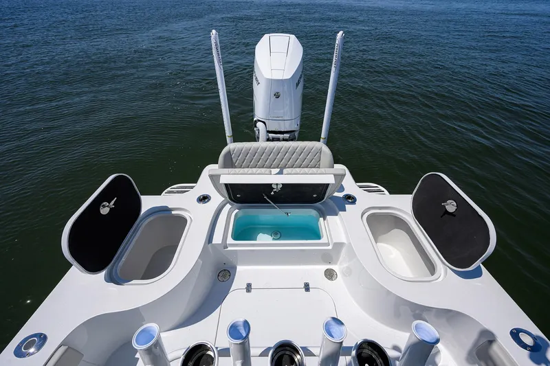 Slide: The Image of 2024 Conch 25 boat deck with storage compartments and motor on open water. - 25