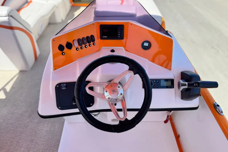 Slide: The Image of 2022 Aloha Pontoon 230 helm with steering wheel and control panel. - 20