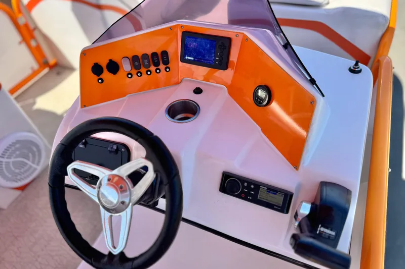 Slide: The Image of Steering console of 2022 Aloha Pontoon 230 with vibrant orange accents and modern controls. - 21