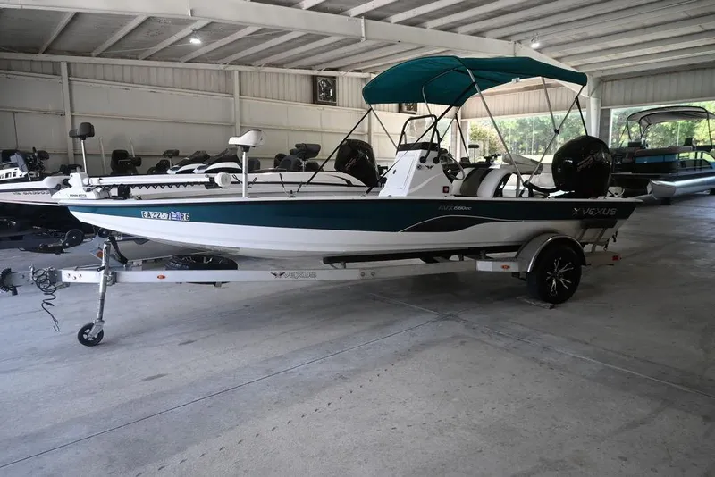 The Image of 2020 Vexus AVX1980CC boat with canopy on trailer in indoor showroom. - 1