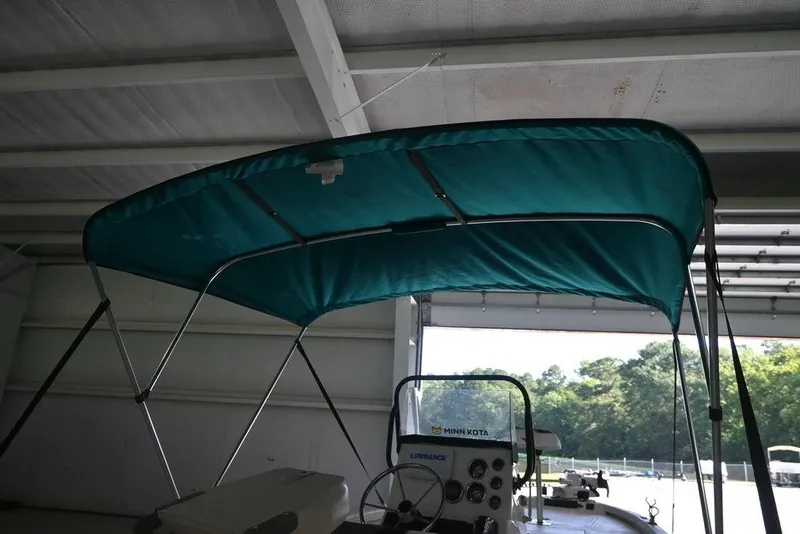 Slide: The Image of 2020 Vexus AVX1980CC boat with teal canopy in a garage setting. - 7