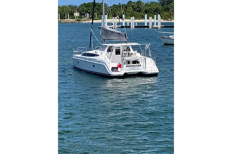 Slide: The Image of Sailing catamaran Gemini Legacy 2013 on water, clear sky, marina background. - 1