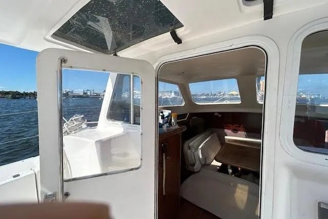 Slide: The Image of 2013 Gemini Legacy boat interior with open door, showcasing cabin and waterfront view. - 32