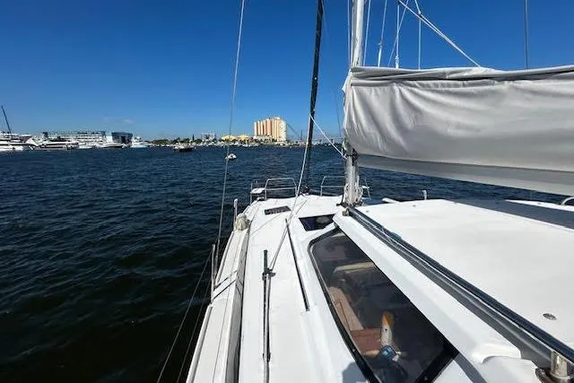 Slide: The Image of Sailboat on water, Gemini Legacy 2013, with cityscape in background under clear blue sky. - 33
