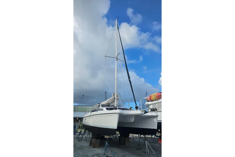 Slide: The Image of 2013 Gemini Legacy catamaran on dry dock under a partly cloudy sky. - 43