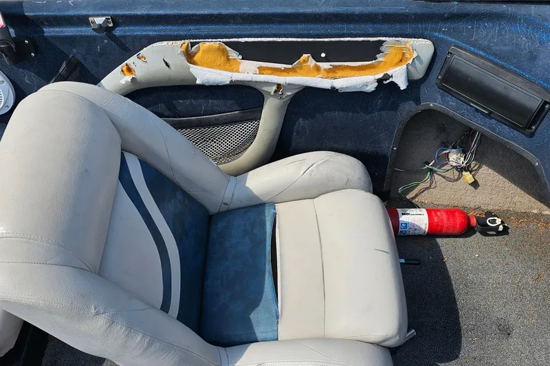 Slide: The Image of 2004 ProCraft 180 Combo boat interior with worn seat and exposed wiring. - 14