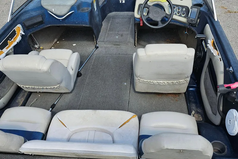 Slide: The Image of 2004 ProCraft 180 Combo boat interior with worn seats and steering console. - 18