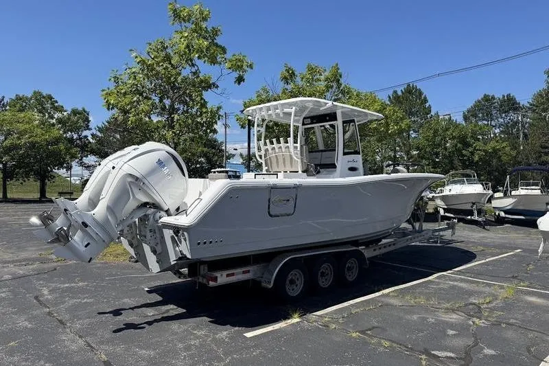 Slide: The Image of 2026 Sea Hunt Gamefish 30 boat on trailer in parking lot, sunny day. - 5