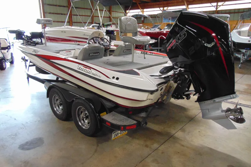 Slide: The Image of 2005 Triton Tr-196 PD boat with powerful engine in a showroom setting. - 3