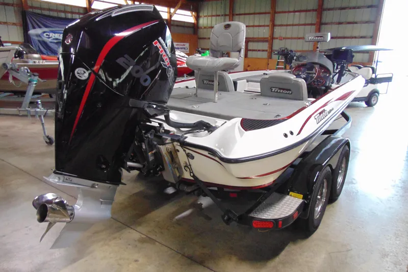Slide: The Image of 2005 Triton Tr-196 PD boat with powerful outboard motor in a showroom setting. - 5