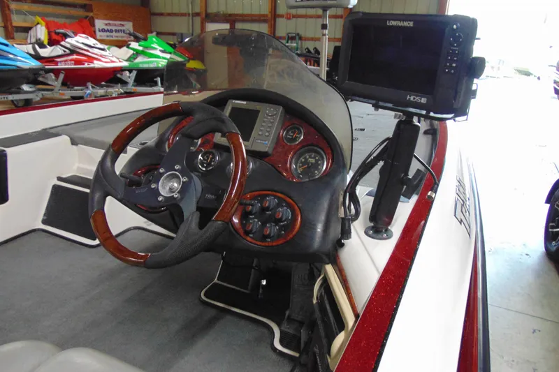 Slide: The Image of 2005 Triton Tr-196 PD boat dashboard with steering wheel and navigation system. - 6