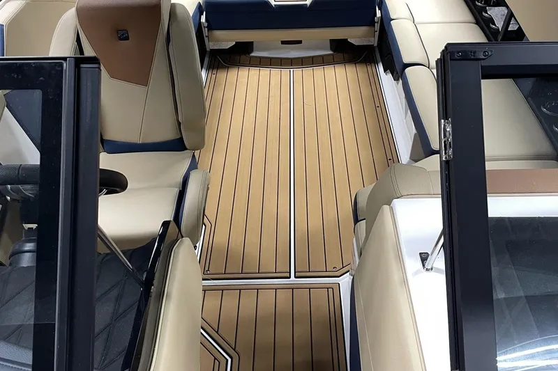 Slide: The Image of 2025 Nautique Super Air Nautique S23 interior with tan and blue seating, sleek design. - 6