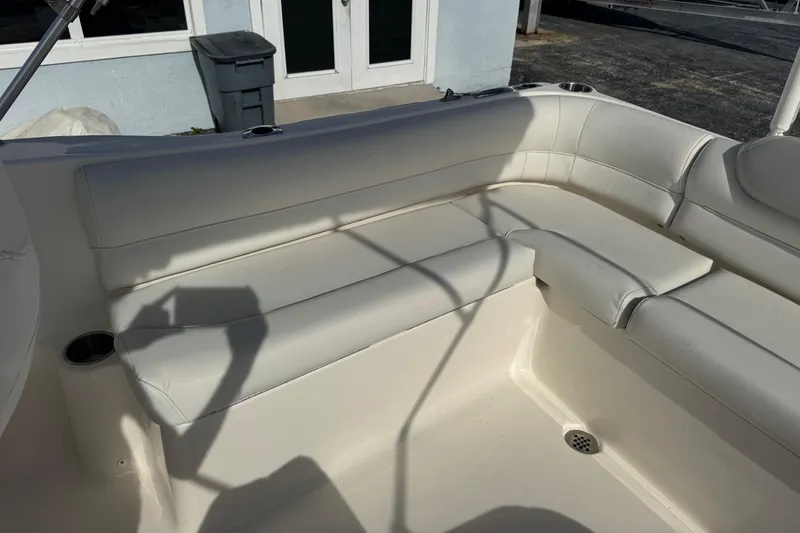 Slide: The Image of 2023 Key West 203 DFS boat interior with white cushioned seating and cup holders. - 18
