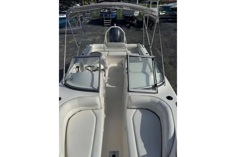 Slide: The Image of 2023 Key West 203 DFS boat with spacious seating and canopy, parked on a lot. - 5