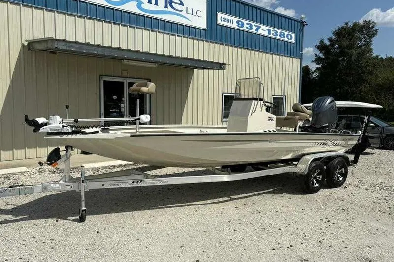Slide: The Image of 2026 Xpress H210B boat on trailer outside a marine dealership. - 2