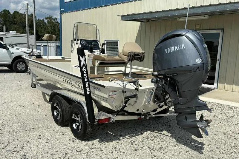 Slide: The Image of 2026 Xpress H210B boat with Yamaha outboard motor, parked on a trailer. - 6
