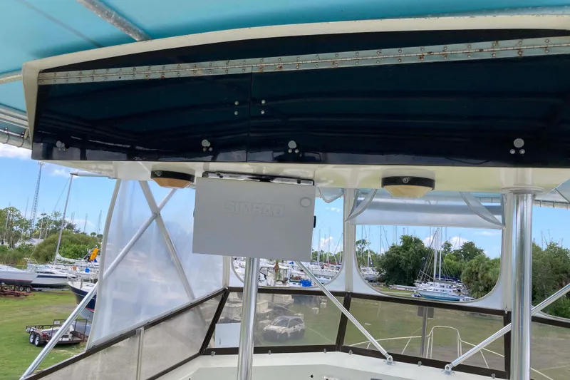 Slide: The Image of 1985 Hatteras Sportfish boat interior with Simrad equipment, marina view in background. - 10