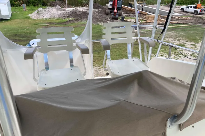 Slide: The Image of 1985 Hatteras Sportfish boat with white captain chairs and covered console. - 11