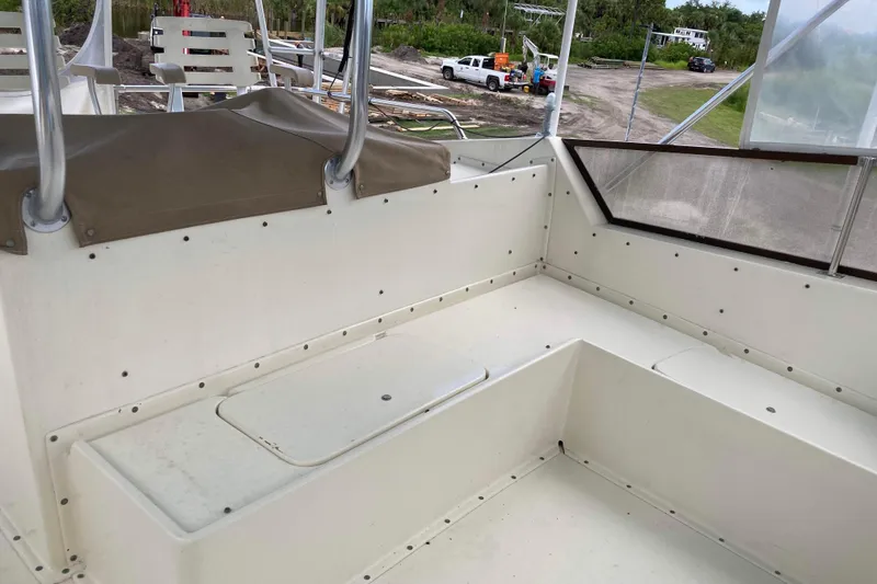 Slide: The Image of 1985 Hatteras Sportfish boat interior with white seating and outdoor view. - 12